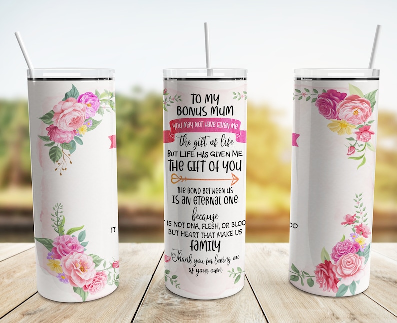 Puede incluir: Un vaso aislado blanco con un dise&ntilde;o floral y el texto "TO MY BONUS MUM". El vaso presenta flores rosas y amarillas y una pancarta rosa. Incluye una pajita y est&aacute; dise&ntilde;ado para bebidas fr&iacute;as.