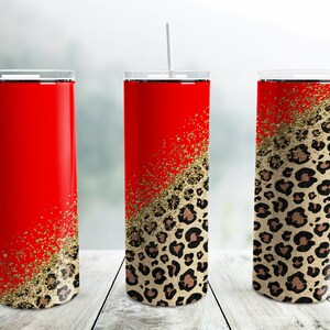 Pode incluir: Três copos de aço inoxidável com tampas e canudos. Os copos são vermelhos com um design de glitter dourado e estampa de leopardo.