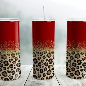 May include: Three red and gold stainless steel tumblers with a leopard print design. The tumblers have a gold glitter accent.