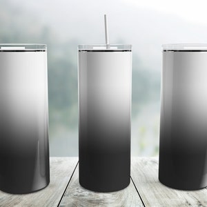 May include: Three stainless steel tumblers with a black to white ombre design. The tumblers have lids and straws.