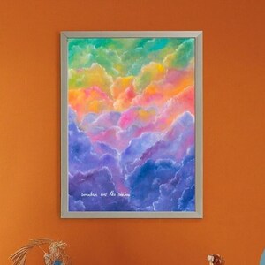 May include: A framed watercolour painting of a colourful sky with clouds. The painting is in a silver frame and has the text "somewhere over the rainbow" written on it.