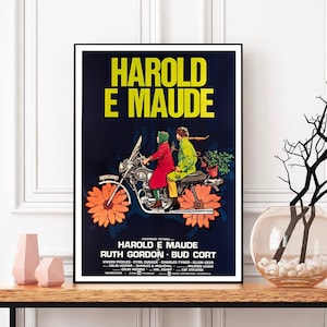 May include: A vintage movie poster for the film "Harold and Maude" featuring a black background with a yellow and orange flower design. The poster features a couple riding a motorcycle with a flower design on the wheels. The text on the poster reads "Harold and Maude" and features the names of the actors and director.