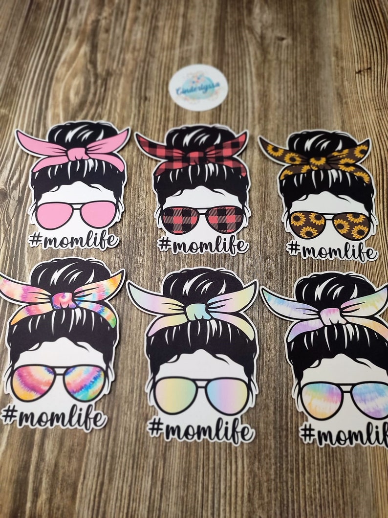 Peut inclure: Six autocollants diff&eacute;rents sur le th&egrave;me de la vie de maman avec une femme portant un chignon d&eacute;sordonn&eacute; et des lunettes de soleil. Chaque autocollant a un motif diff&eacute;rent sur le bandeau et les lunettes de soleil. Le texte #momlife est sous chaque autocollant.