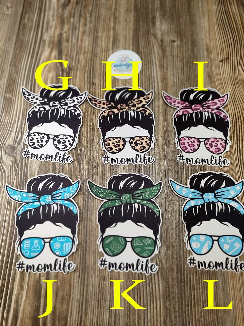 Peut inclure: Six designs diff&eacute;rents d'une femme avec un chignon d&eacute;sordonn&eacute; portant des lunettes de soleil et un bandana. Les bandanas sont de motifs diff&eacute;rents, notamment un imprim&eacute; l&eacute;opard, des fleurs roses, des symboles m&eacute;dicaux verts et bleus et des symboles dentaires bleus et blancs. Chaque design comporte le texte "#momlife" en dessous.