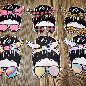 May include: Six black and white silhouette images of a person with a messy bun hairstyle wearing sunglasses and a patterned headband. The headbands are pink, red and black plaid, yellow with sunflowers, light blue tie-dye, purple tie-dye, and pink tie-dye.