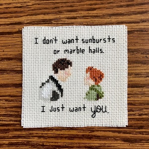 May include: Cross-stitch embroidery with a quote from the movie "The Princess Bride": "I don't want sunbursts or marble halls. I just want you."