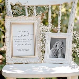 May include: A white chair with a sign that reads "This seat is reserved in loving memory of the mother of the groom, Emerson Parker. Forever in our hearts today and always."  A framed black and white photo is on the chair.