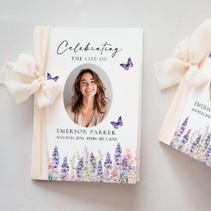 May include: A white booklet with a floral design and a photo of a woman. The booklet has the text "Celebrating the Life of Emerson Parker August 10, 20XX February 3, 20XX" printed on the front.