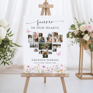 May include: A white memorial sign with a heart-shaped collage of photos surrounded by butterflies. The text "forever in our hearts" is at the top, and the name "EMERSON JENKINS" and dates "AUGUST 10, 20XX - FEBRUARY 3, 20XX" are at the bottom. The sign is decorated with a watercolor floral border.
