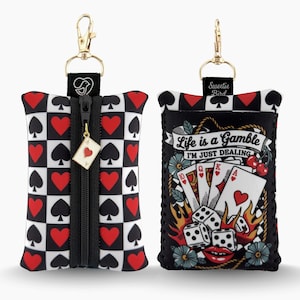 Peut inclure: Deux étuis pour désinfectant pour les mains en néoprène avec quincaillerie dorée. L'un présente un motif en damier noir et blanc avec des cœurs rouges et des piques noirs. L'autre a un motif de style tatouage avec le texte "Life is a Gamble I'm Just Dealing."