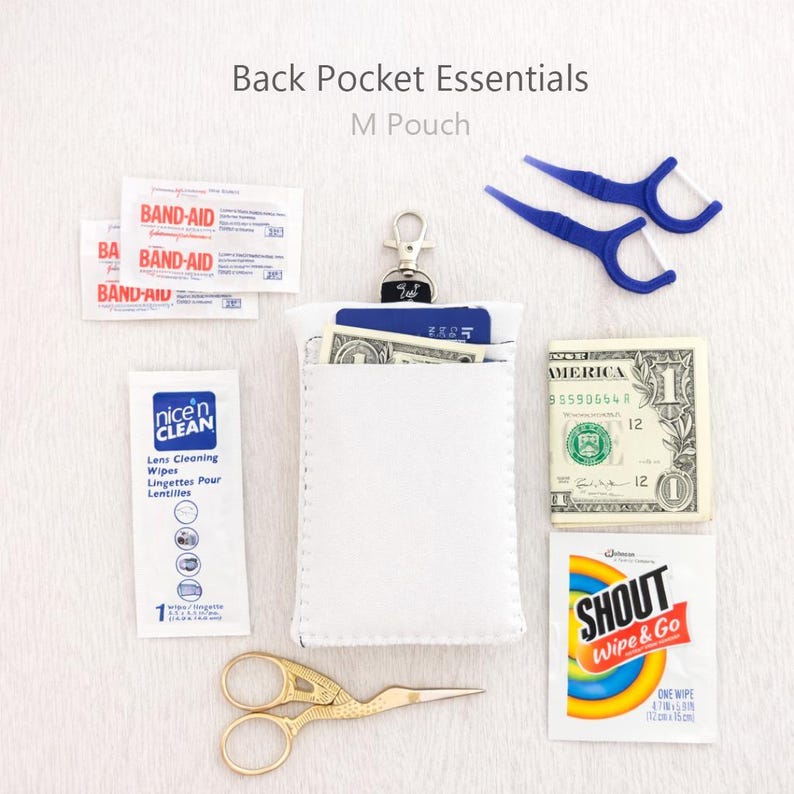 May include: A white M pouch with essentials like Band-Aids, lens cleaning wipes, a dollar bill, Shout wipe, floss picks, and gold scissors. The text "Back Pocket Essentials" and "M Pouch" are visible.