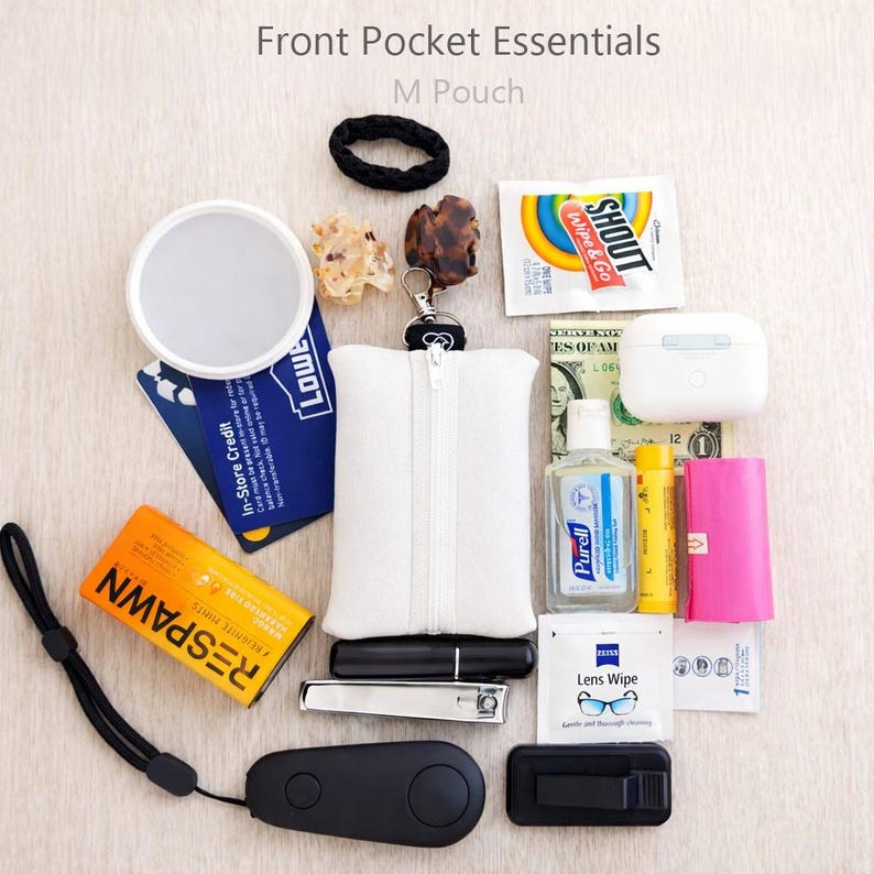 May include: A collection of everyday carry items, including a white zippered pouch, a black hair tie, a compact mirror, and a small bottle of hand sanitizer. The image also features a nail clipper, a credit card, and a pack of lens wipes.
