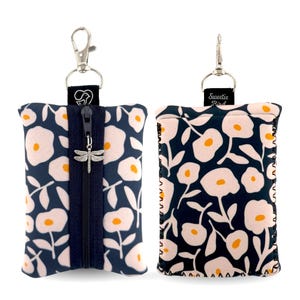 May include: Two rectangular pouches featuring a dark navy blue background with a repeating pattern of light pink flowers with yellow centers. One pouch has a central vertical zipper with a silver dragonfly charm and a metal swivel clasp.