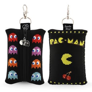 May include: Black Pac-Man themed pouch with a zipper closure and a silver-tone clip. The front features colorful pixelated ghosts, while the back displays the Pac-Man logo, a yellow Pac-Man, and cherries.