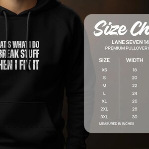 Pode incluir: Camisola de moletom com capuz preta com o texto "That's what I do I break stuff then I fix it" em branco. Tabela de tamanhos com medidas em polegadas para XS a 3XL.