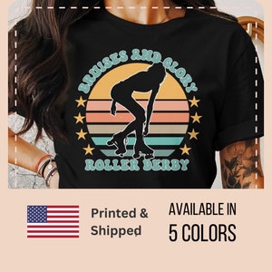 Pu&ograve; includere: Maglietta nera con una grafica di tramonto retr&ograve; e il testo "Bruises and Glory Roller Derby".