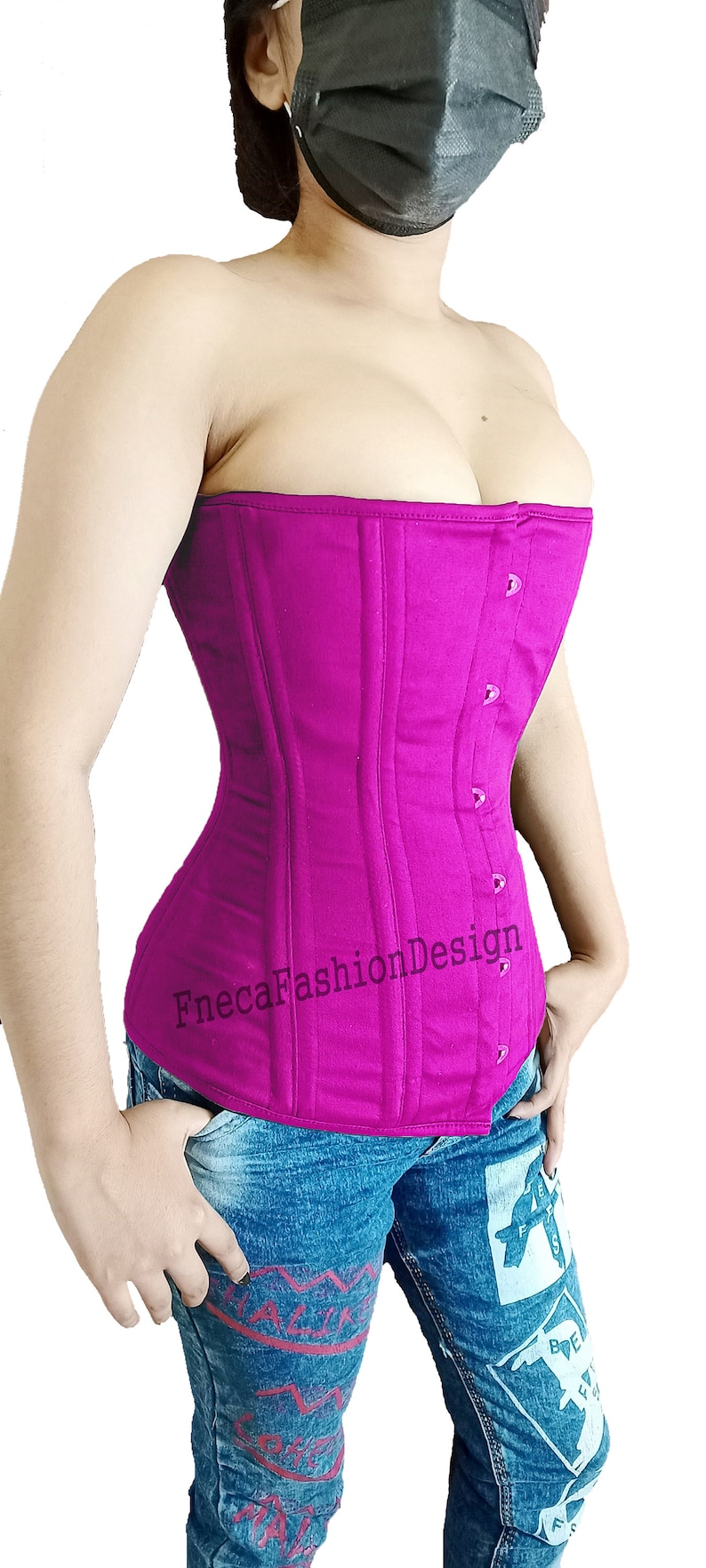May include: A fuchsia pink corset with a busk closure and a satin ribbon detail. The corset is made of a sturdy cotton fabric and has a smooth, matte finish. The corset is worn by a person with blue jeans.