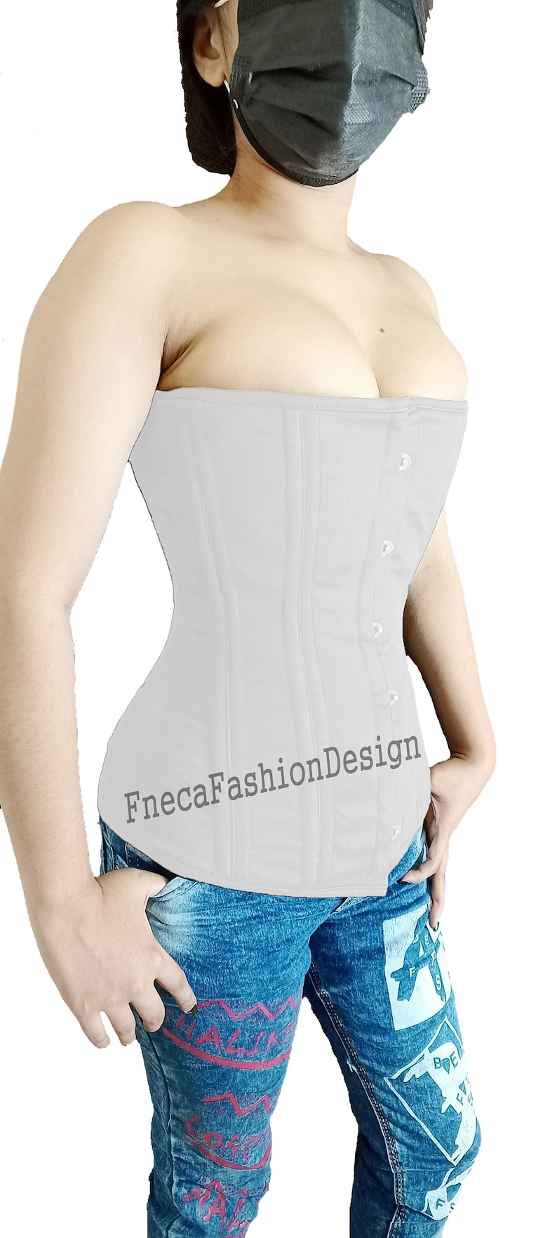 May include: A white corset with a busk closure and a FnecaFashionDesign logo. The corset is worn over a pair of blue jeans with a graphic print.