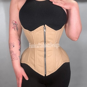 May include: A tan corset with a front zipper closure. The corset is worn over a black halter top. The text "FanicaFashionDesign" is visible on the bottom of the corset.