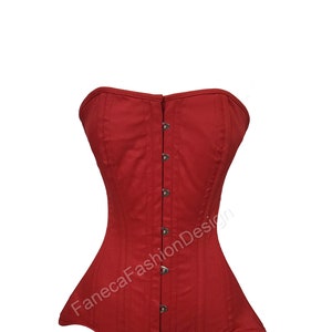 May include: A red strapless corset with a busk closure and metal eyelets. The corset has a smooth, satin-like finish and is designed to cinch the waist.