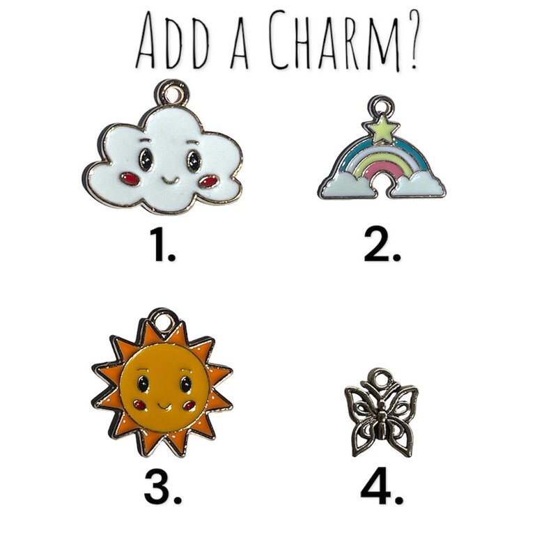 Puede incluir: Cuatro opciones de charms para un proyecto de joyer&iacute;a: una nube blanca con una cara sonriente, un arco&iacute;ris con una estrella, un sol amarillo con una cara sonriente y una mariposa plateada.