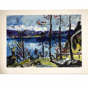 May include: An impressionistic painting of a lake scene with mountains in the background. The artwork features a vibrant blue lake, trees with red and yellow leaves, and a small building on the right. The painting is on a white paper.