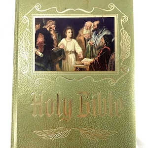 May include: Green hardcover Holy Bible with gold lettering and a framed illustration. The illustration depicts a young person in a white robe surrounded by several older men. The cover has a textured pattern.