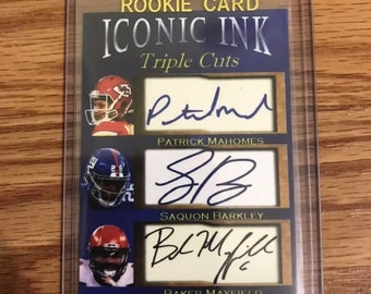 Puede incluir: Una tarjeta de novato azul y dorada con el título "Iconic Ink Triple Cuts" y tres firmas: Patrick Mahomes, Saquon Barkley y Baker Mayfield.