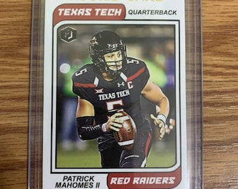Op de afbeelding: Een rode en witte rookiekaart met Patrick Mahomes II, een quarterback van Texas Tech. De kaart heeft een zwarte en gouden rand en de tekst "Rookie Card", "Texas Tech", "Quarterback", "Patrick Mahomes II" en "Red Raiders".