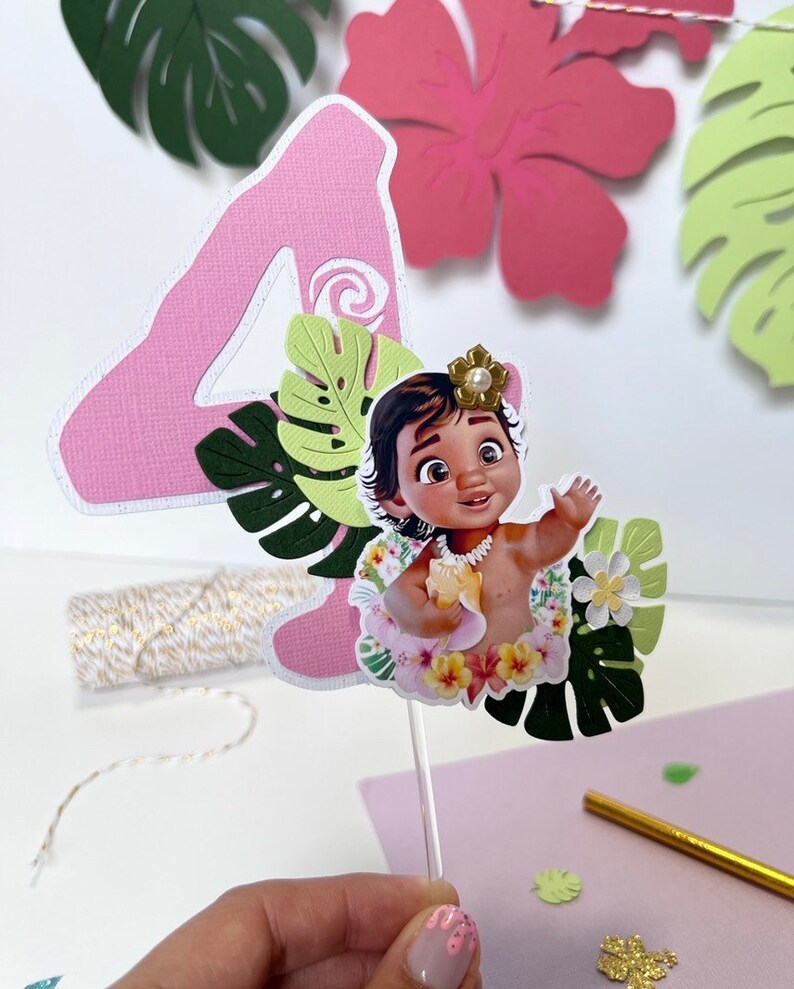 Pode incluir: N&uacute;mero quatro de papel rosa com um recorte de Moana do filme da Disney Moana, usando um colar de flores e segurando uma concha. O n&uacute;mero quatro &eacute; decorado com folhas e flores de papel verde.
