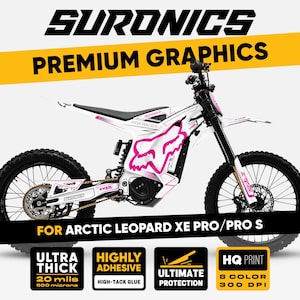 Peut inclure: Motocross électrique SurRon blanc et rose avec des graphismes "FOX RACER". Le vélo a des pneus et une suspension noirs, avec le texte "FOR ARCTIC LEOPARD XE PRO/PRO S". L'image comprend également du texte sur les caractéristiques du produit.