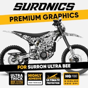 Puede incluir: Una moto de cross eléctrica Surron Ultra Bee en blanco y negro con un diseño gráfico de estilo graffiti. La imagen presenta el texto "Street Ghost" y "Premium Graphics". El gráfico se describe como ultra grueso, altamente adhesivo y que proporciona la máxima protección.