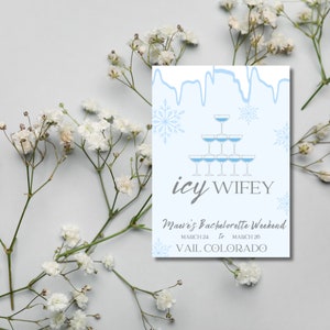 Op de afbeelding: Een blauwe en witte uitnodigingskaart met een afbeelding van een champagne-glaspiramide en sneeuwvlokken. De tekst luidt "icy wifey" en "Maeve's Bachelorette Weekend, March 24 to March 26, Vail Colorado."