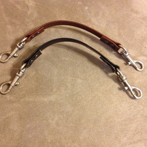 May include: Two leather straps with silver swivel clasps. One strap is brown and the other is black.