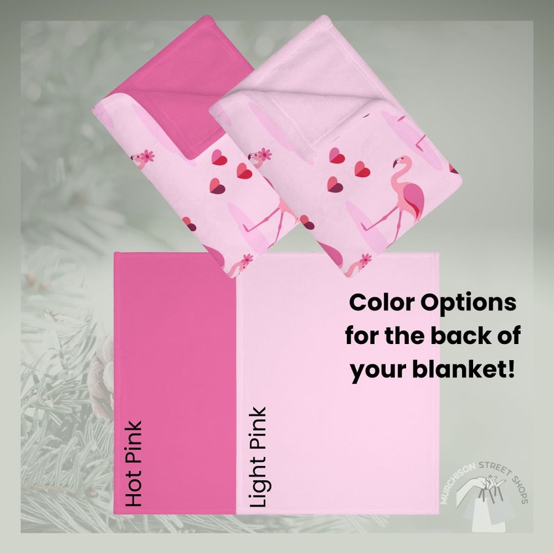Sage green background with folded blankets showing the back color options of light pink or hot pink.
