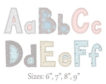 Puede incluir: Un conjunto de letras del alfabeto de tela en varios colores y patrones, incluyendo gris, rosa y azul. Las letras están cosidas con una puntada decorativa y tienen un diseño de patchwork. Las letras están disponibles en tamaños de 6, 7, 8 y 9 pulgadas.