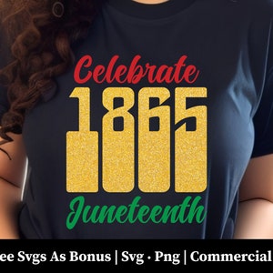 May include: A dark blue t-shirt with the text "Celebrate 1865 Juneteenth" in red, gold, and green lettering. The text is stylized with a glitter effect. The shirt is being worn by a person.