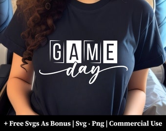 May include: A navy blue t-shirt with the words "GAME day" in white block letters. The word "day" is written in a cursive font. The shirt also includes the text "+ Free Svgs As Bonus | Svg • Png | Commercial Use".