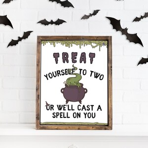 May include: A white sign with a brown wooden frame, featuring a cartoon cauldron with green bubbling liquid and the text "Treat yourself to two or we'll cast a spell on you". The sign is decorated with black bats on a white brick wall background.