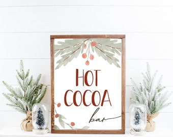 Könnte beinhalten: Ein Holzschild mit weißem Hintergrund und einem grün-roten Aquarelldesign aus Stechpalmenblättern und Beeren. Das Schild trägt die Aufschrift "Hot Cocoa Bar" in roten Buchstaben.