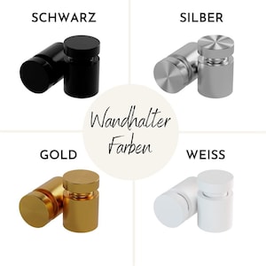 May include: Four wall mounts in different colors: black, silver, gold, and white. The wall mounts are round and have a screw-on design. The text "Wandhalter Farben" is visible in the center of the image.