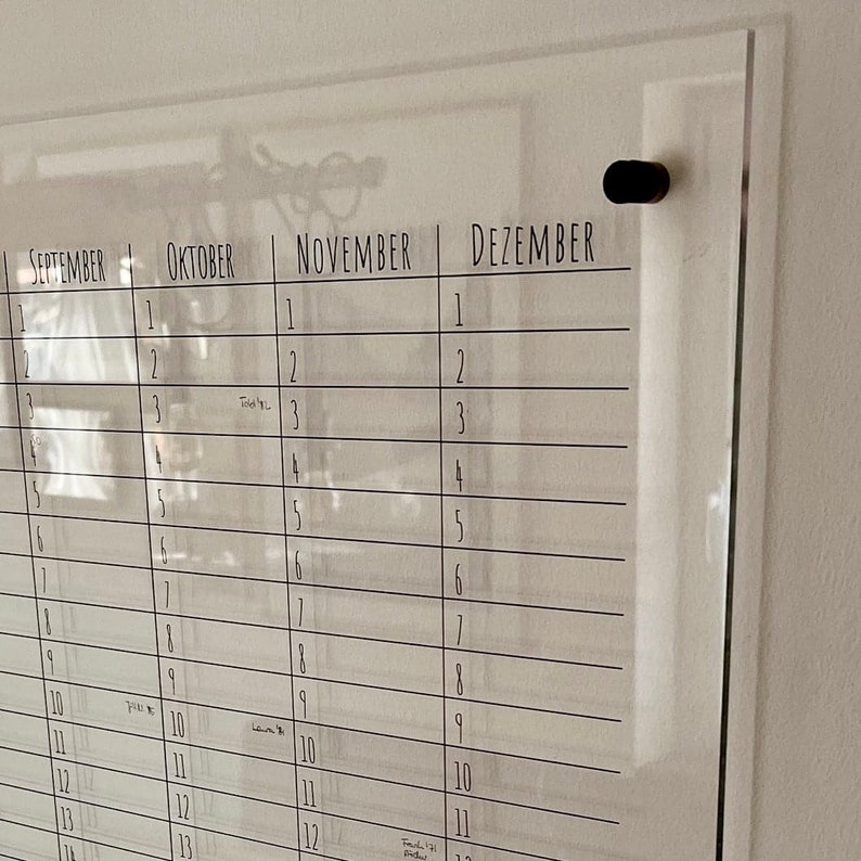 May include: A clear acrylic dry erase calendar with the months September, October, November, and December labeled. The calendar has lines for each day of the month and is designed to be hung on a wall.
