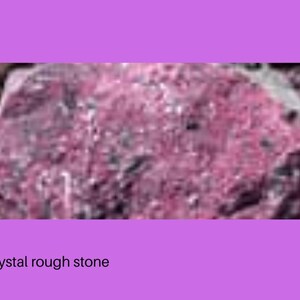 Op de afbeelding: Een ruwe robijnkristalsteen met een diep magenta en donkerrood kleurenpalet en een getextureerd, ongelijkmatig oppervlak. Het mineraalexemplaar vertoont natuurlijke kristallijne formaties en donkere insluitingen in de onregelmatige vorm.