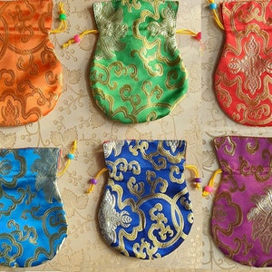 May include: Six small drawstring pouches with different coloured fabrics and gold embroidery. The pouches are made of silk and have a traditional Chinese design.