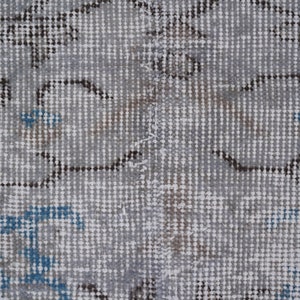 May include: Close-up of a gray and white patterned rug with blue accents. The rug has a woven texture and a subtle distressed look.