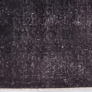 Puede incluir: Primer plano de una alfombra oscura y texturizada con aspecto envejecido. La alfombra tiene una combinaci&oacute;n de colores blanco y negro, con un patr&oacute;n de peque&ntilde;os puntos y l&iacute;neas blancas irregulares sobre un fondo oscuro. Los bordes de la alfombra est&aacute;n deshilachados.
