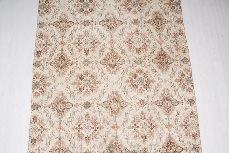 Peut inclure: Un tapis de couleur cr&egrave;me avec un motif floral brun et beige qui se r&eacute;p&egrave;te.