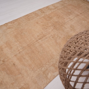 May include: A light brown rug with a subtle pattern. The rug is made of natural fibers and has a rustic look.