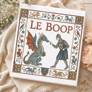 May include: A square canvas print featuring a medieval-style illustration with the text LE BOOP. A knight in chainmail and a blue tunic touches the nose of a green dragon. The scene is framed by floral borders, small dragons, and a shield.