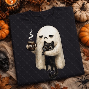 May include: A black t-shirt featuring a graphic of a white ghost holding a black mug with the text MEH and a black cat. The ghost has a bored expression, and the black cat has wide eyes. The design is centered on the front of the shirt.